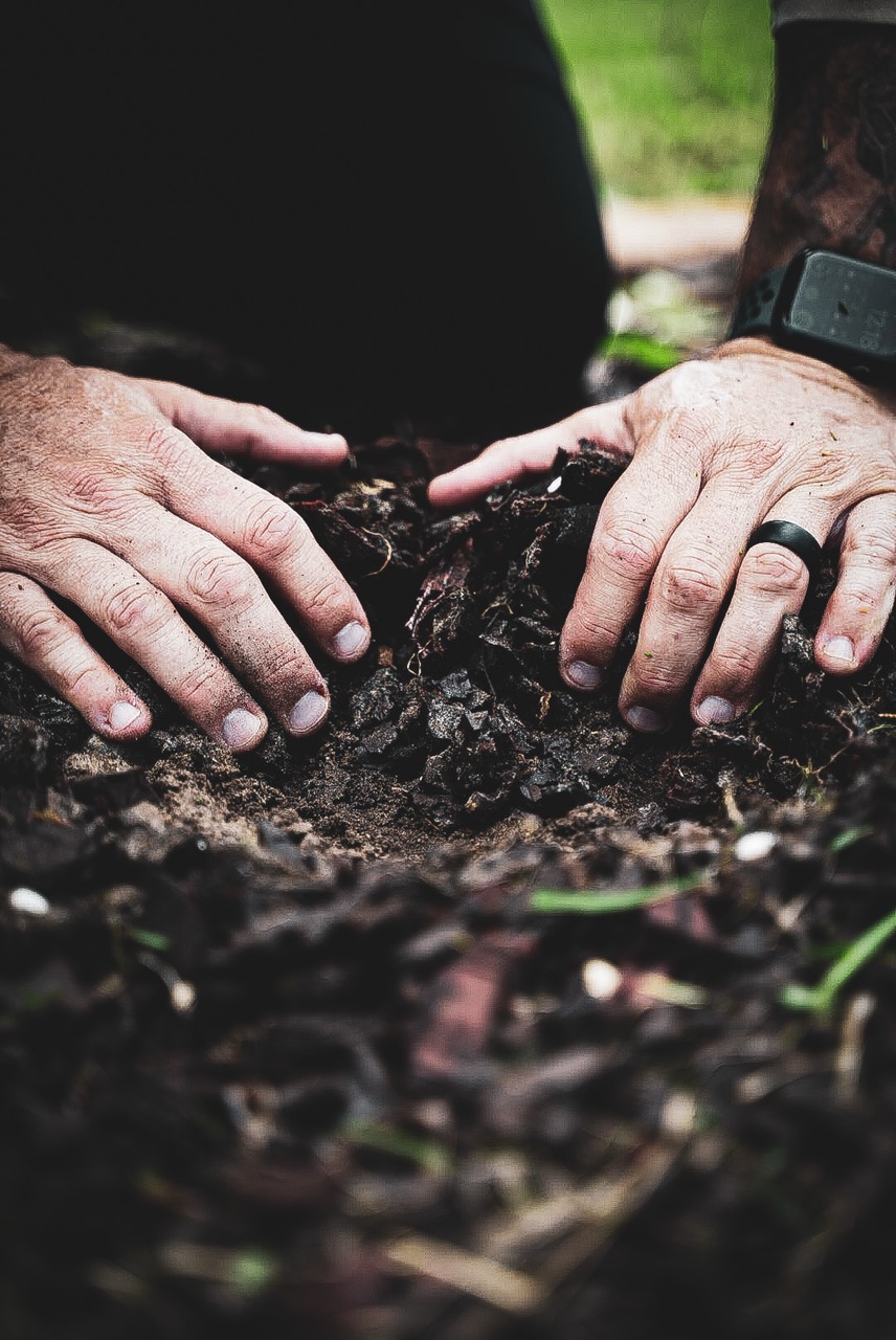 Hands spreading mulch, a SouthShore LawnLife detail frame
