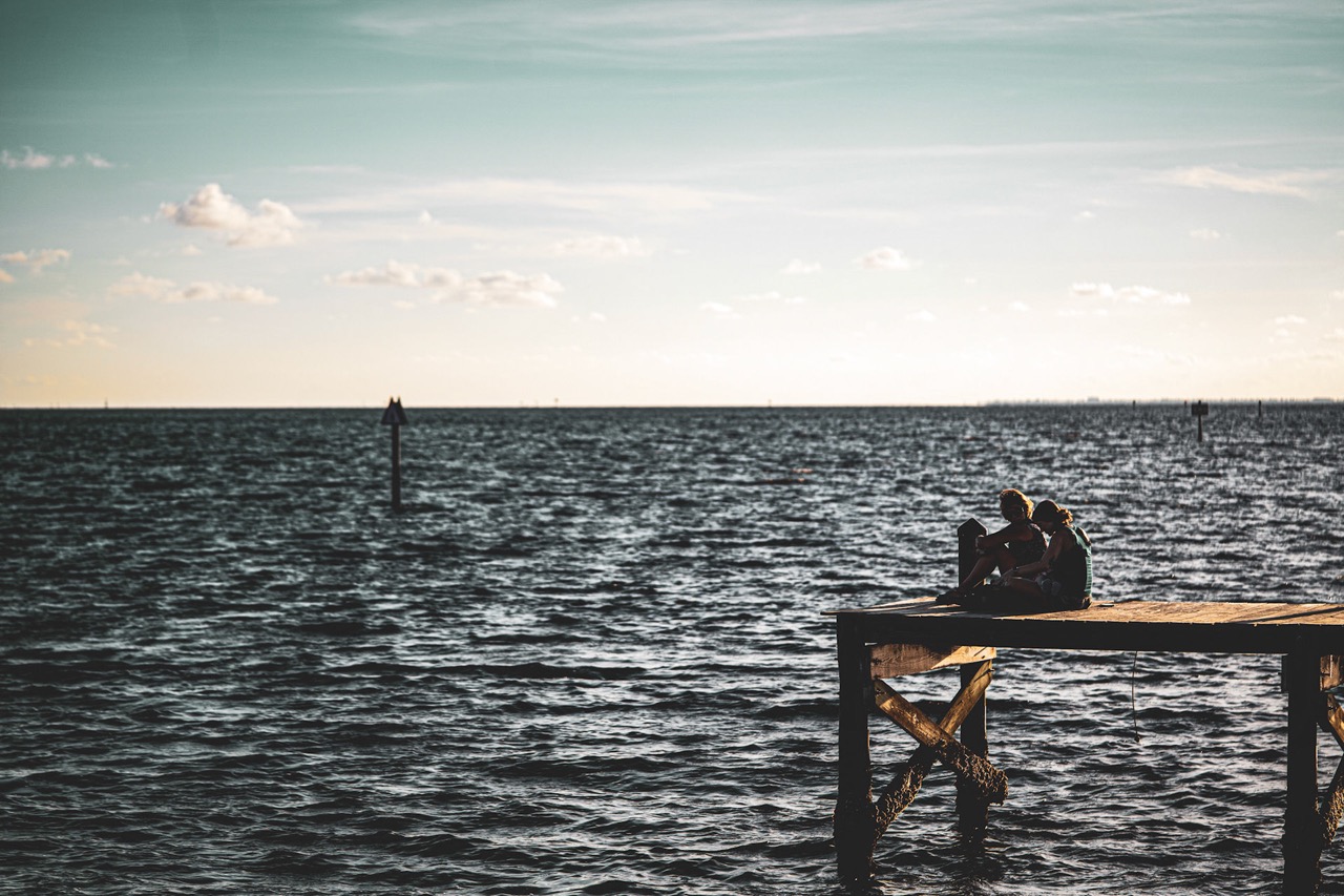 Couple on a waterfront dock at golden hour