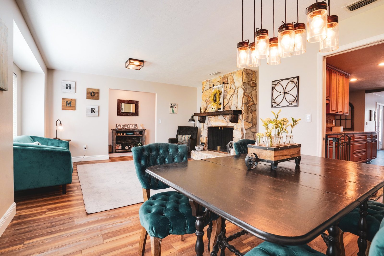 Dining room with stone fireplace and mason jar pendant lighting
