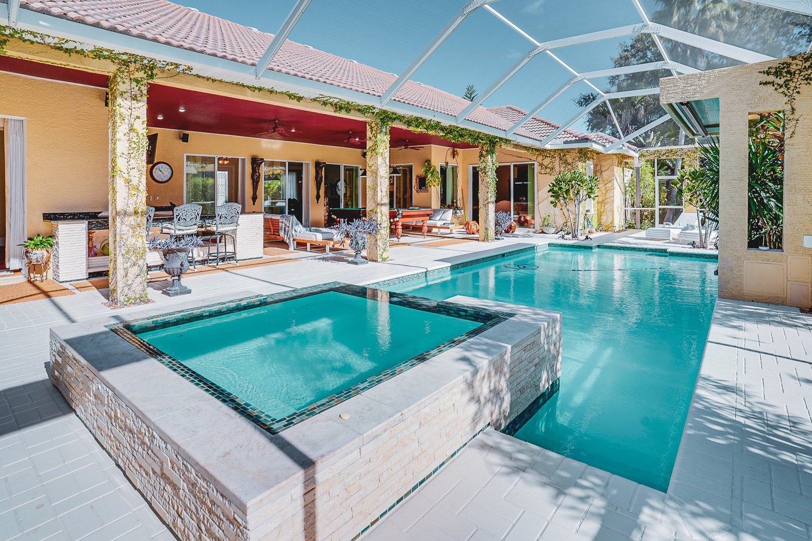 Screen-enclosed pool with hot tub and outdoor living space