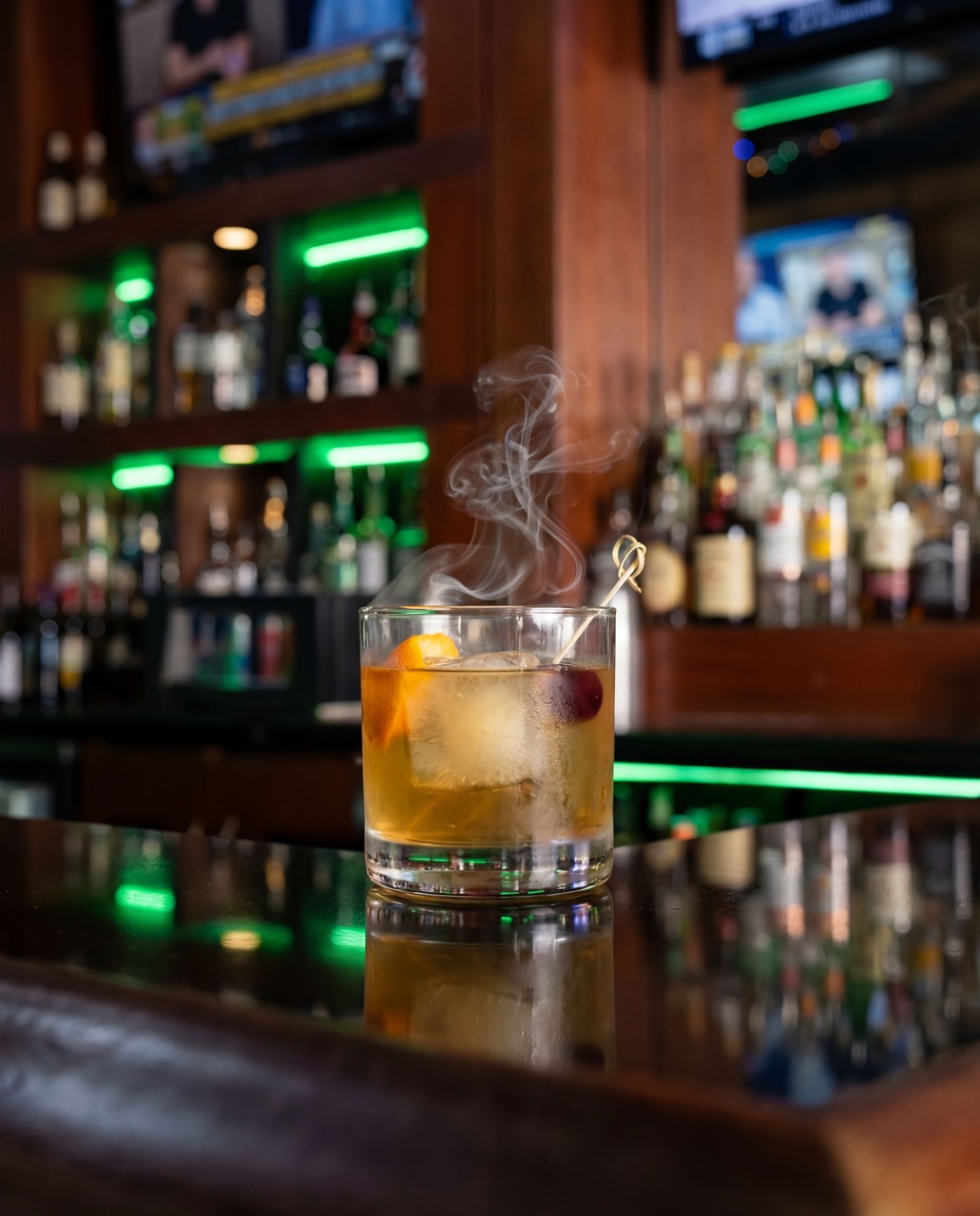 A smoked old fashioned cocktail under glass at Bad Monkey