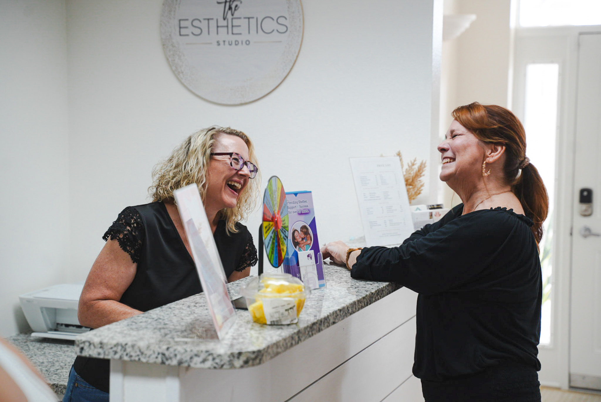 Clients laughing in the reception of The Esthetics Studio